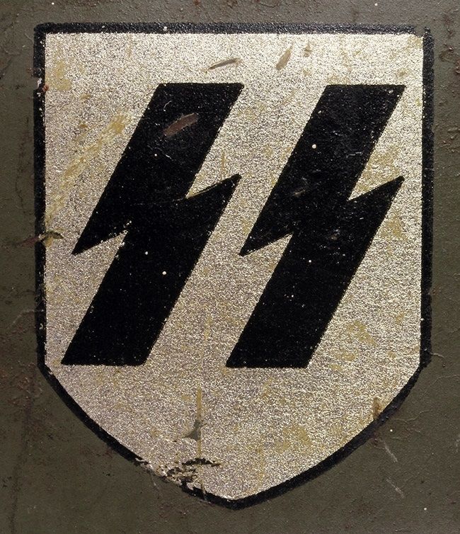 SS decal on an M34. The decal manufacturer is C.A. Pocher. Note the sharp angles of the runes. Another feature is the bottom line of both runes are in line with the point where the shield makes a turn to become narrower and pointed (the «break»).  These decals were often used on early production helmets such as the M35 SS DD (double decal) helmets produced by ET and Quist. 