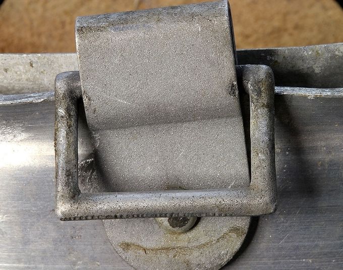 The chinstrap bale on an aluminum liner. Note the square shaped corners of the bale. Very common in M35 and early M40 helmets.