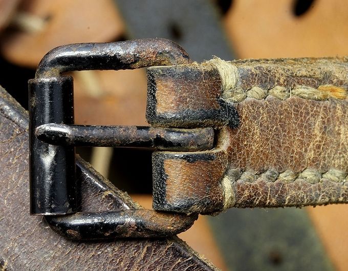 This is an early style, black painted roller buckle that is sometimes found on M35 helmets and WW1 reissues.