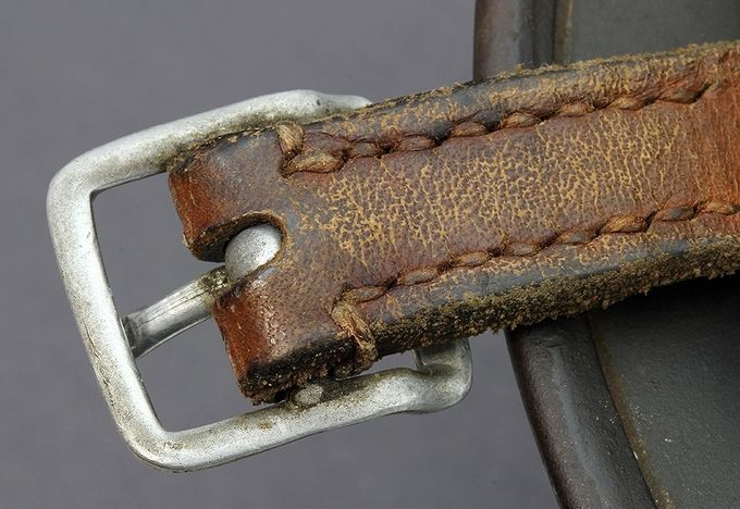 Reverse side of a chinstrap short end with aluminum buckle on an M35. Notice the parallel seams, each with eight stiches.