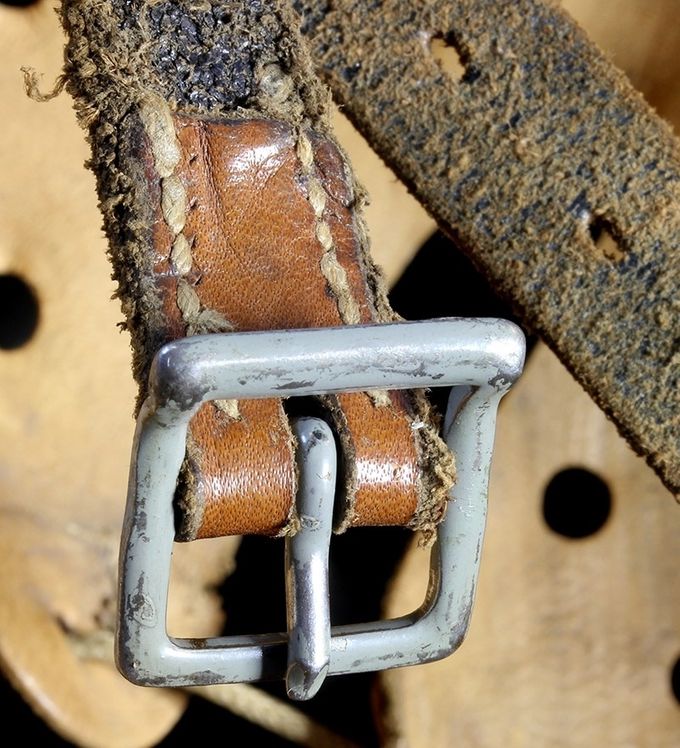 Steel buckle painted in blue-grey on an M40. Steel buckles without paint exist, but this is often due to heavy wear and age resulting in paint loss. Notice the oval buckle prong holes on the long end. 