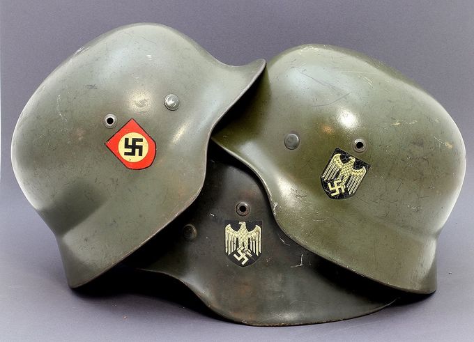 Three M35 helmets with smooth paint demonstrating the great variation in the color “feldgrau