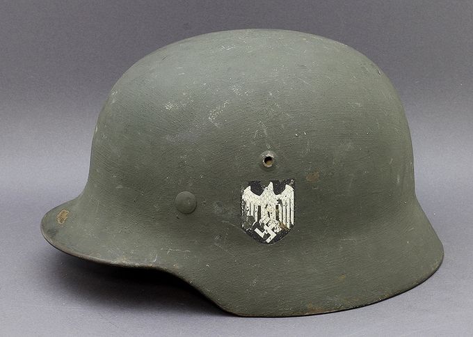 An M35 ET64 classical reissue with light grey sand-textured paint. While the paint has a rough sand texture, it is not regarded as a sand camouflage helmet. Notice the reissue-type Heer decal that has partially flaked off due to the rough surface. This type of reissue is common in Norway. 
