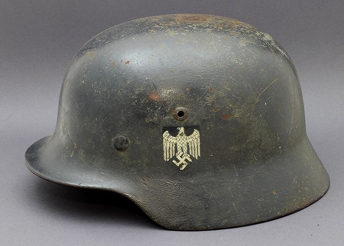 M35 ET66 repainted in dark blue. Most helmets in this color are Luftwaffe however this example is Heer. The factory applied decal has been painted around.