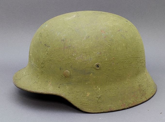 M40 ET68 with an intense green sand paint. Notice the low vent hole which is a manufacturing flaw. The decal which is clearly showing through the thin paint layer is belived to be KM. Found near a KM coastal fort. There are several other helmets found with the same paint and texture in other Norwegian collections.