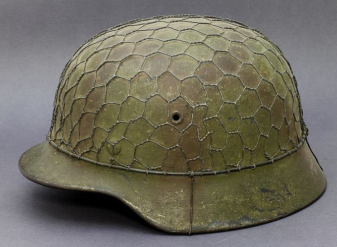 M40 ET64 camouflage helmet. Painted in green and red-brown and has a another construction of half-basket chickenwire (another Norwegian collection).