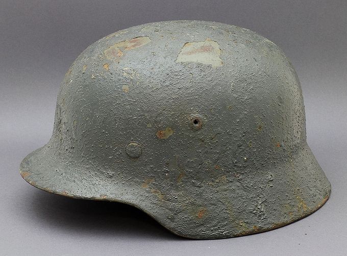 M35 Quist 68 with dark blue paint. The paint has been mixed with sand/stones and brushed on the helmet in a very thick lumpy layer. 