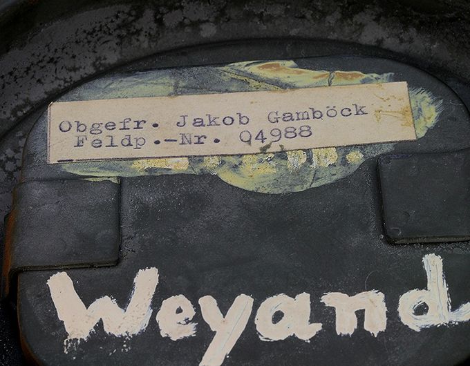 Double naming on the inside of the cover of a gas mask canister. Obergefreiter Jacob Gamböck with field post number 04988 served in HKB 48/977 (Heeres Küsten Batterie 48, Regiment 977) placed in Røtingi near Korsfjord in the western coast of Norway.