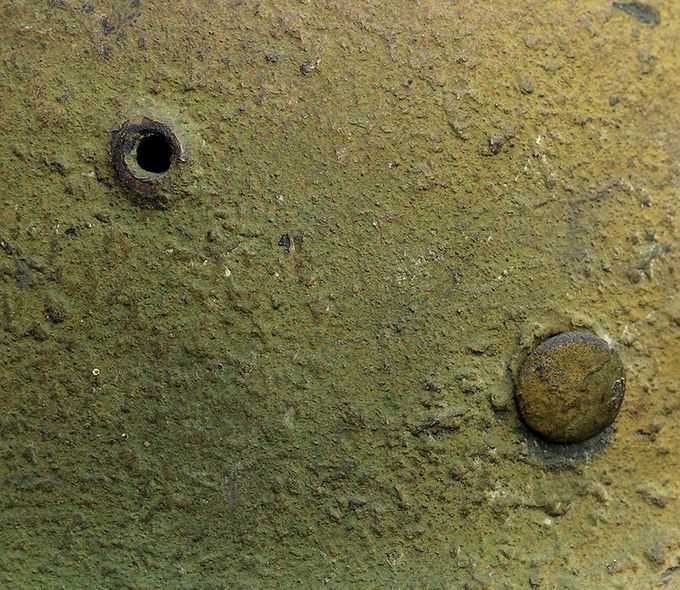 Close-up picture of the vent hole and on the rivet heads. Notice the paint strructure, sawdust and woodchip in the paint.